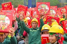 Construction workers at the Pearl Theatre project site (Ha Noi) joyfully receive Tet gifts from the organisers of the “Xay Tet 2026” programme.