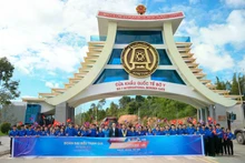 Delegates pose for a commemorative photo at the Bo Y International Border Gate. (Photo: doanthanhnien.vn)