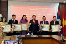 Ambassador Nguyen Minh Tam presents Certificates of Merit to five Vietnamese-language teachers in Laos. (Photo: DUY TOAN)
