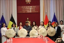 Do Phuoc Trung, Deputy Director of the Ho Chi Minh City Department of Culture and Sports, presents non quai thao to the Vietnamese Ao Dai Heritage Club in the Kingdom of Belgium.