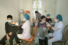 Medical staff administer vaccinations to students at a provincial school in Hung Yen.
