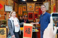International visitors experience the traditional new year calligraphy activity (Photo: VNA)