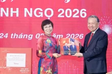 VNA General Director Vu Viet Trang (L) presents a photo book to Party General Secretary To Lam. (Photo: VNA)