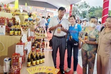 Delegates visit an exhibition booth showcasing Phu Quoc fish sauce products at the 2025 Phu Quoc Fish Sauce Festival.