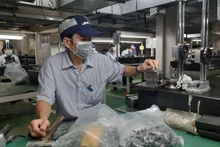 Workers at Juki Vietnam Co., Ltd., Tan Thuan Export Processing Zone, Ho Chi Minh City are manufacturing industrial sewing machine components.