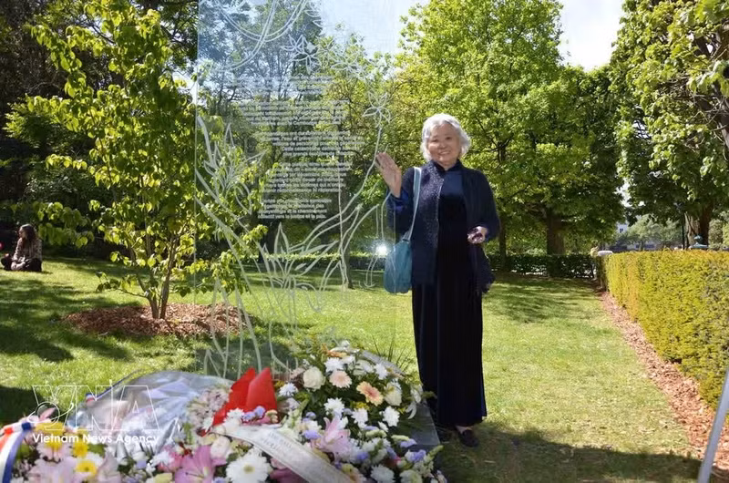Tran To Nga poses beside the memorial stele dedicated to victims of Agent Orange/dioxin was inaugurated at Choisy Park in Paris, France on April 25 (Photo: VNA)