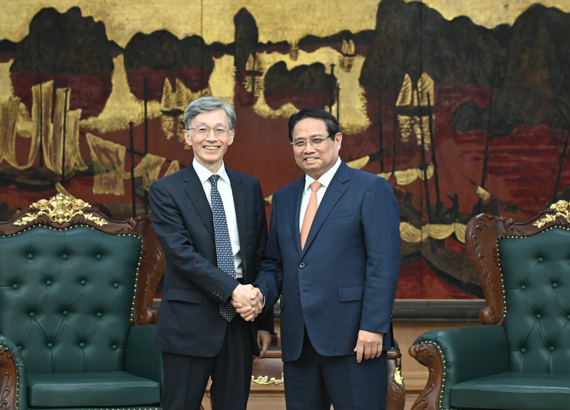 Prime Minister Pham Minh Chinh (R) welcomes Deputy Managing Director of the International Monetary Fund Kenji Okamura. (Photo: NDO)