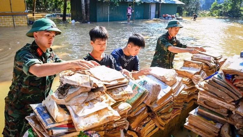 Soldiers and students drying books and school supplies at the Ethnic Boarding Secondary and High School of Huu Lung District, Lang Son Province. (Photo: THANH DAT)