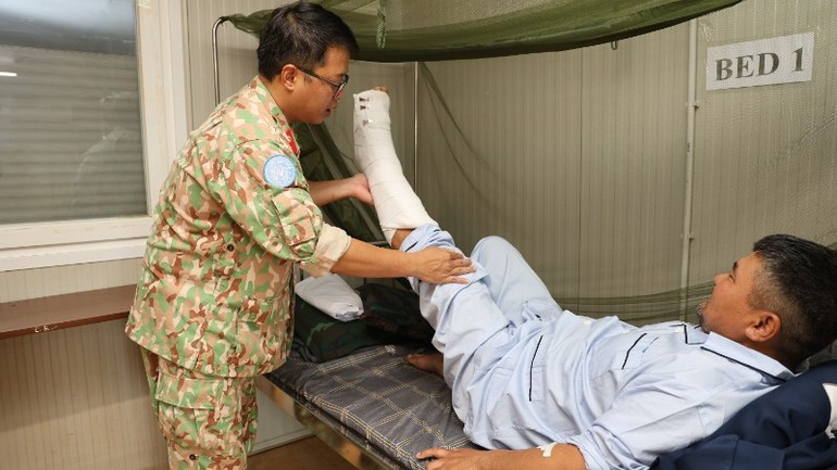 Dr Tran Duc Tai examines the patient after surgery. (Photo: TIEN PHUC)