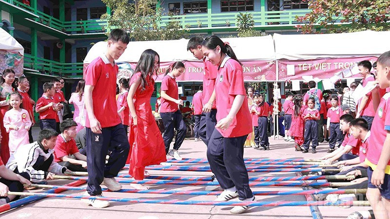 Schoolchildren join a bamboo pole dance at the festival