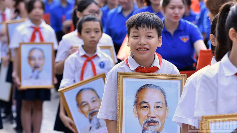Students carried a portrait of President Ho Chi Minh at the flag-raising ceremony in Ha Noi 