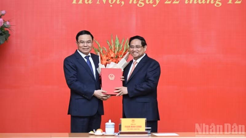 PM Pham Minh Chinh presents congratulatory flowers to Acting Minister of Industry and Trade Le Manh Hung. (Photo: NDO)
