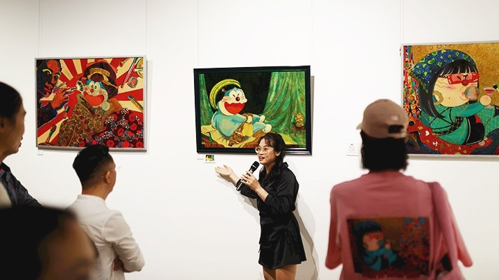 Phan Tu Tran presents her works to exhibition visitors (Photo courtesy of the artist)