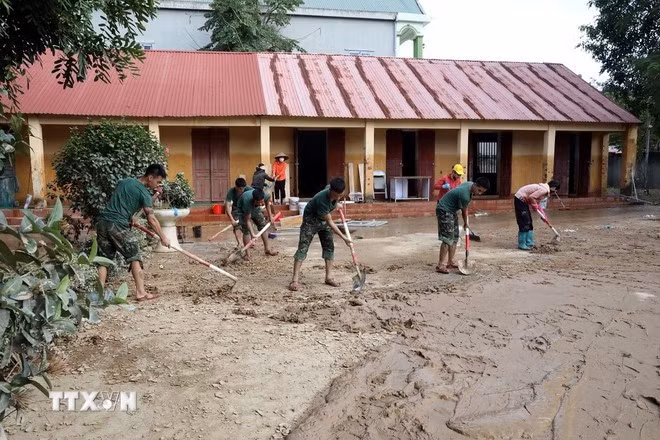 Officers and soldiers from Battalion 6, Regiment 12, Division 3 under Military Region 1 help Yen Binh commune's Secondary School in Lang Son province clean up classrooms and school grounds. (Photo: VNA)