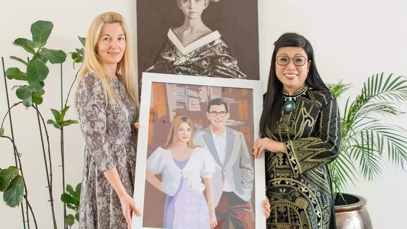 Vietnamese PM’s spouse (R) presents a mosaic to Estonian PM’s wife. (Photo: VNA)