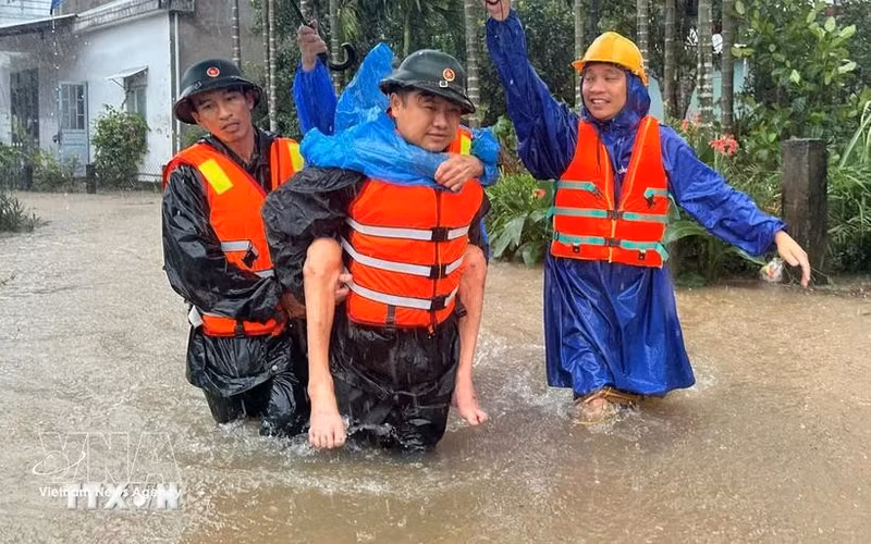 Military forces take a resident from a flooded area. (Photo: VNA)