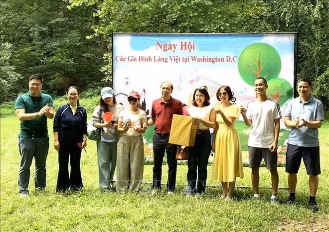 Ambassador Nguyen Quoc Dung (middle) presents gifts to winners of sports games at the festival. (Photo: VNA)