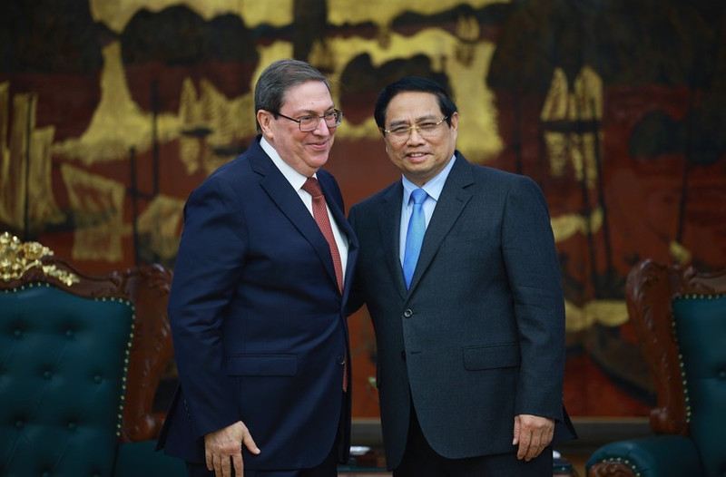 Prime Minister Pham Minh Chinh (R) welcomes Bruno Rodríguez Parrilla, Politburo member and Minister of Foreign Affairs of Cuba, who is visiting Viet Nam as special envoy of the Communist Party and State of Cuba (Photo: VNA)