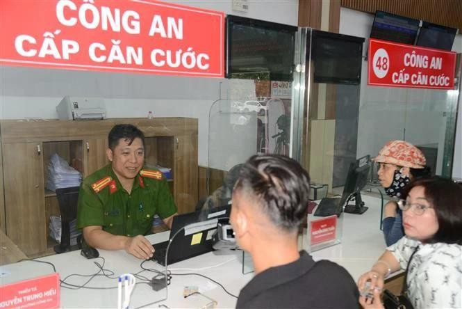A police officer help residents change citizen identity cards at the public service centre of the newly formed Hon Gai ward, Quang Ninh province. (Photo: VNA)