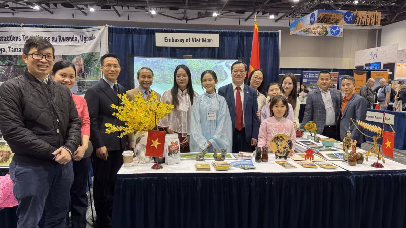 Ambassador Pham Vinh Quang (seventh from left) poses for a photo with staff of the Vietnamese Embassy in Canada at the Vietnam booth at the exhibition. (Photo: VNA)