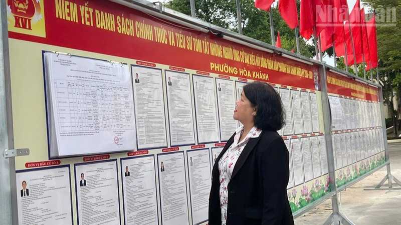 Voters in Hoa Khanh ward read information on the public notice board.
