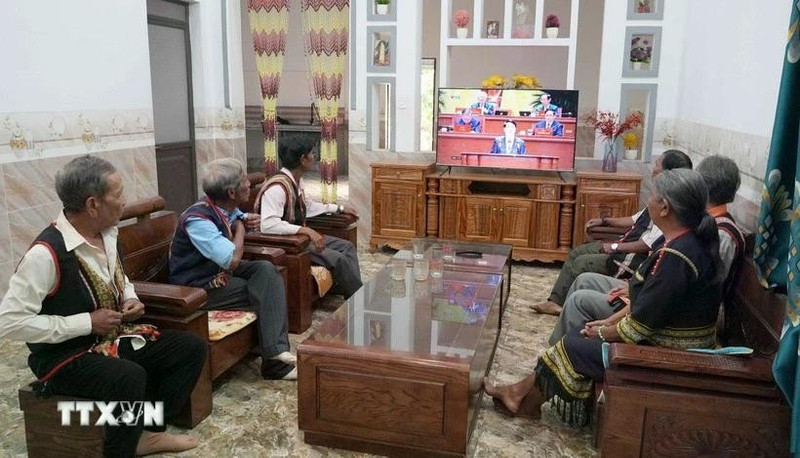 Village elders, respected figures, and villagers of Plei Jo Drop hamlet, Ia Chim commune, Quang Ngai province, watch the opening session of the 14th National Party Congress. (Photo: VNA)