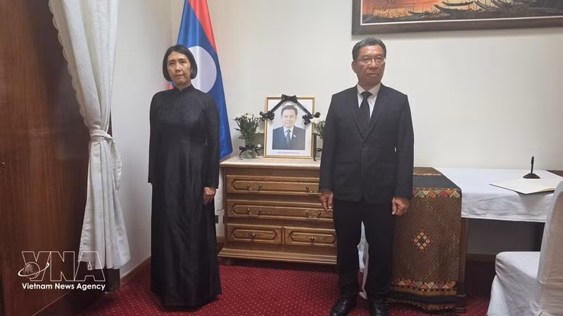 Vietnamese Ambassador to Belgium and Permanent Representative of Viet Nam to the European Union (EU) Nguyen Huong Tra (left) pays tribute to Xaysomphone Phomvihane, Politburo member and President of the Lao National Assembly (Photo: VNA)