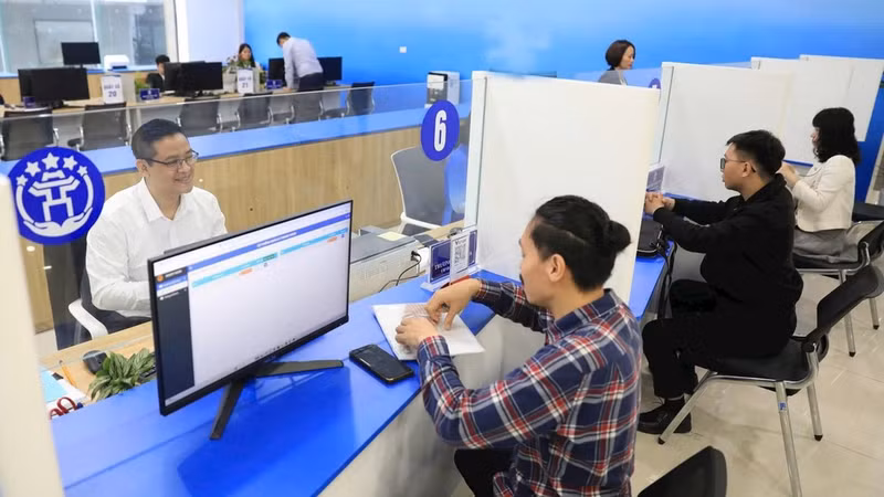 Supporting people in completing online administrative procedures at the Tay Ho Branch of the Public Administration Service Centre. (Photo: QUANG PHONG)