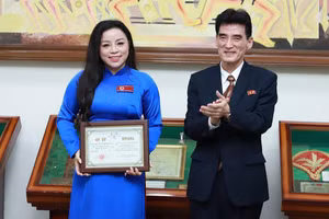 Ambassador Ri Sung Guk presents the gold cup and certificate of merit to Meritorious Artist To Nga. (Photo courtesy of the artist)
