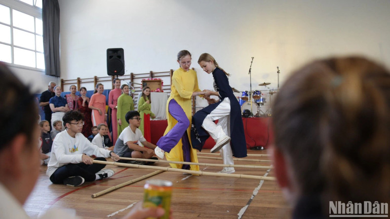 French girls wear ao dai while doing the bamboo dance.
