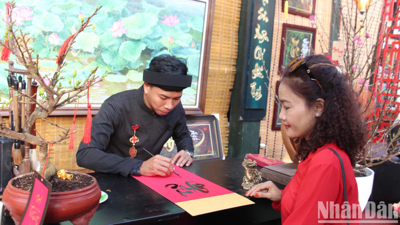 Some stalls sold pre-written calligraphy after completing the decoration. The booth is elaborately decorated with dragon mascot paintings, calligraphy, statues and blooming peach blossoms.