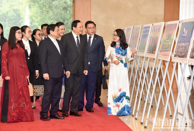 Prime Minister Pham Minh Chinh introduces photos of socio-economic cooperation between the two countries to his Lao counterpart, Sonexay Siphandone.