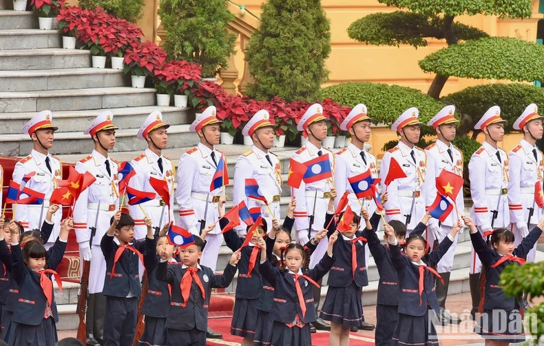 Children wave flags to the two Prime Ministers.
