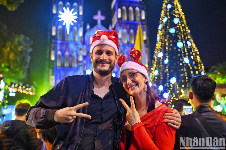 A foreign coupe poses for a picture in front of St. Joseph Cathedral in Hanoi's Hoan Kiem District. (Photo: Thanh Dat)