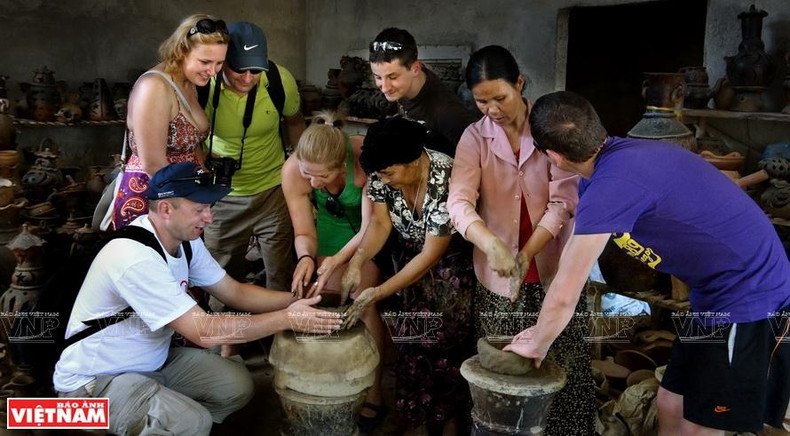 Foreign visitors try their hands at making Bau Truc pottery. (Photo: Vietnam Pictorial)