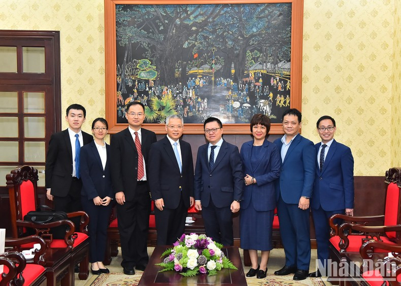 Le Quoc Minh, Hu Zhaoming and other delegates pose for photos after the meeting.
