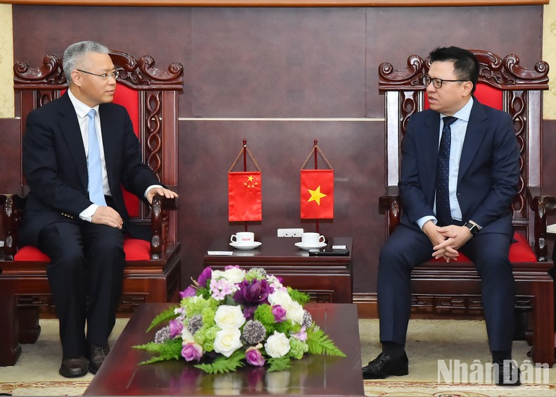 Editor-in-Chief of Nhan Dan Newspaper Le Quoc Minh receives Hu Zhaoming, Spokesperson and Director General of the Bureau of Public Information and Communication, International Department of the CPC Central Committee.