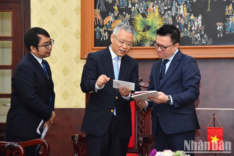 Le Quoc Minh and Hu Zhaoming exchange information after the meeting.