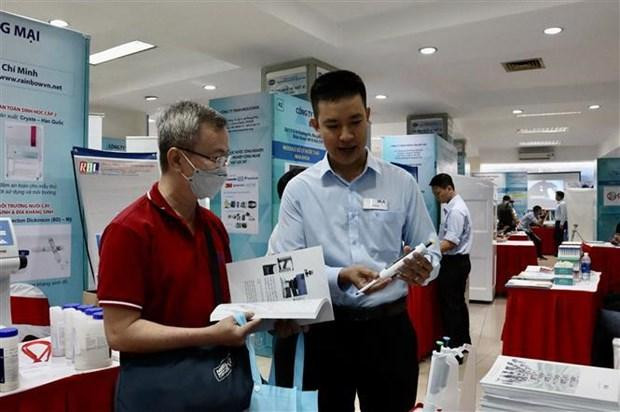 An exhibitor introduce new technology to a visitor at the fair. (Photo: VNA)