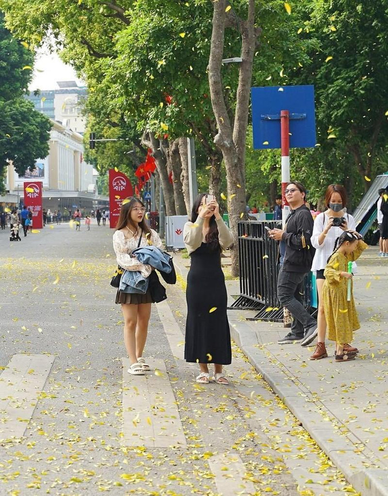Young people save the moment of autumn in Hanoi at the pedestrian street of Hoan Kiem lake. (Photo: Khanh Hoa/VNA)