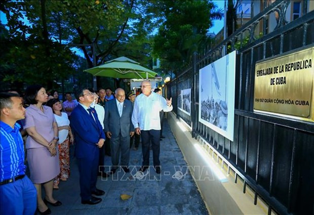 Delegates visit the photo exhibition themed "Great victory of Vietnam and Cuba" (Photo: VNA)