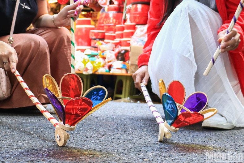"Den cu” (spinning wheel lantern) is one of the traditional Mid-Autumn toys. Making a “den cu” takes a lot of work. The process starts with the sharpening of bamboo sticks to smaller and thinner ones. These are knit together into a spinning-top shape. Then, colourful paper is stuck to the frame. Next is to attach a wooden wheel to the frame and tie it with steel wire core so that the lamp can move when pushed back and forth. "Den cu” (spinning wheel lantern) is one of the traditional Mid-Autumn toys. Making a “den cu” takes a lot of work. The process starts with the sharpening of bamboo sticks to smaller and thinner ones. These are knit together into a spinning-top shape. Then, colourful paper is stuck to the frame. Next is to attach a wooden wheel to the frame and tie it with steel wire core so that the lamp can move when pushed back and forth.
