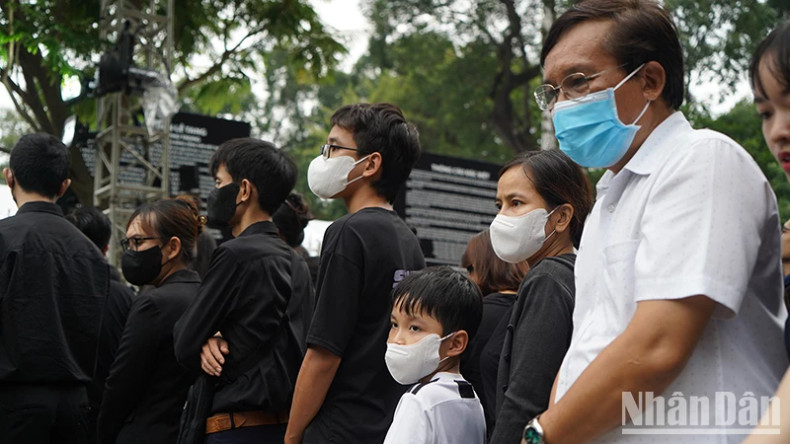 Children and their parents wait to enter the Reunification Hall to pay their respects to General Secretary Nguyen Phu Trong after work.