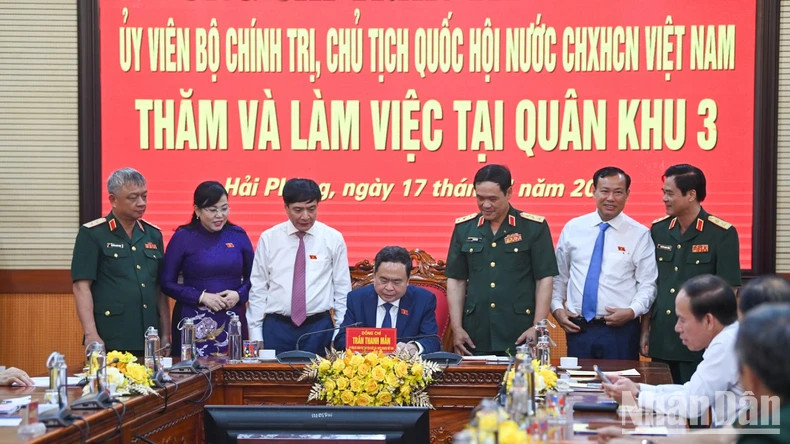 NA Chairman Tran Thanh Man writes in the traditional golden book of Military Region 3 Command.