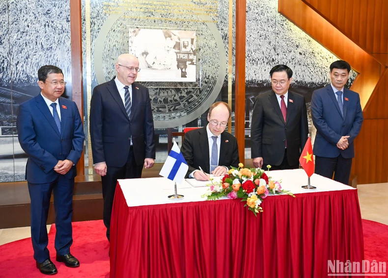 Speaker of the Parliament of Finland, Jussi Halla-aho, writes in a guestbook in the traditional room.