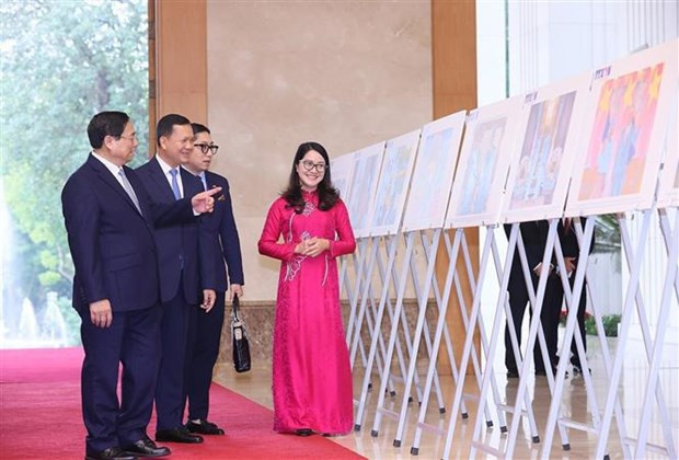 The two leaders visit photo exhibition featuring the land and people of Vietnam and Cambodia, and their good relations (Photo: VNA)