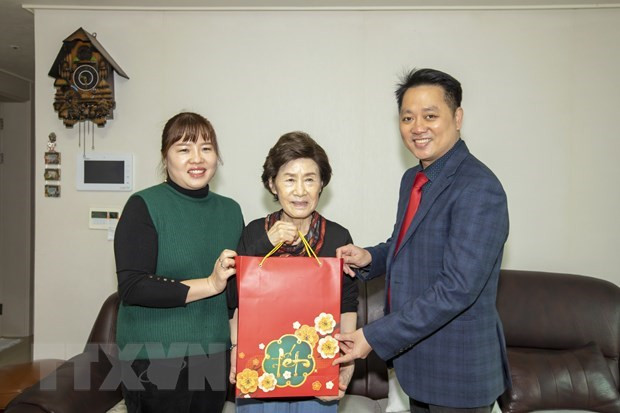 Chargé d'affaires Nguyen Viet Anh (R) presents a gift to a member of Do Thi Thanh Nga's family (Photo: VNA)