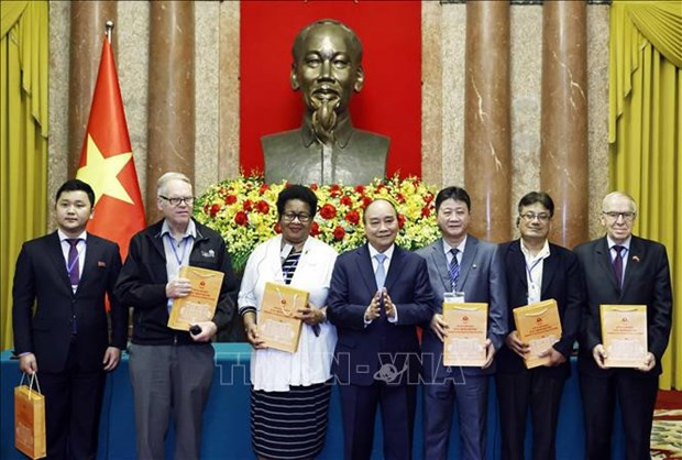 President Nguyen Xuan Phuc (C) presents gifts to delegates to the 22nd Assembly of the World Peace Council. (Photo: VNA)