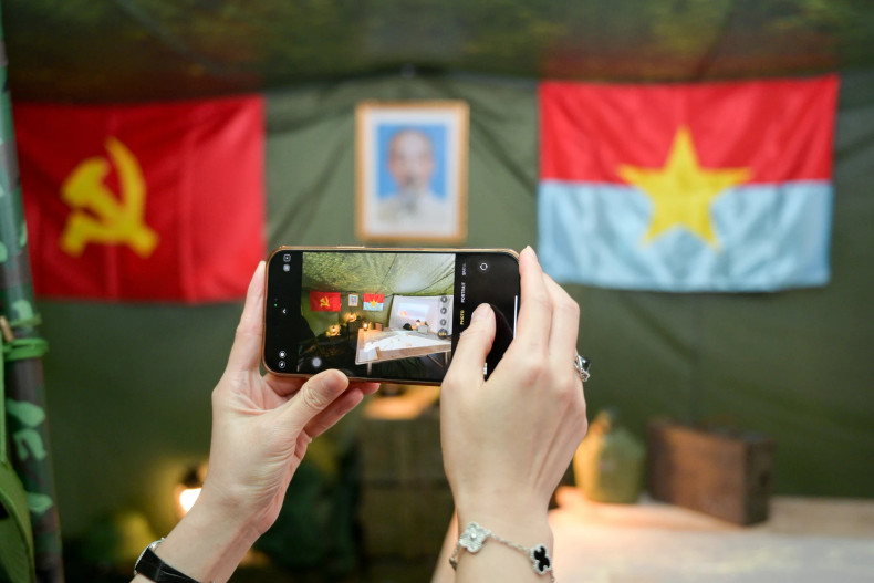 Visitors capture the recreated space of a field tent at the exhibition.