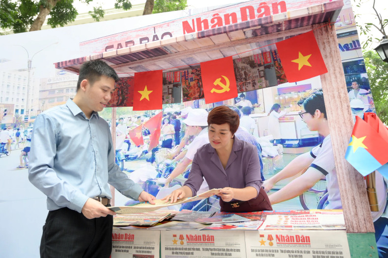 The exhibition features 11 enlarged front pages of Nhan Dan Newspaper editions published on April 30 in key years including 1975, 1980, 1985, 1990, 1995, 2000, 2005, 2010, 2015, and 2020.